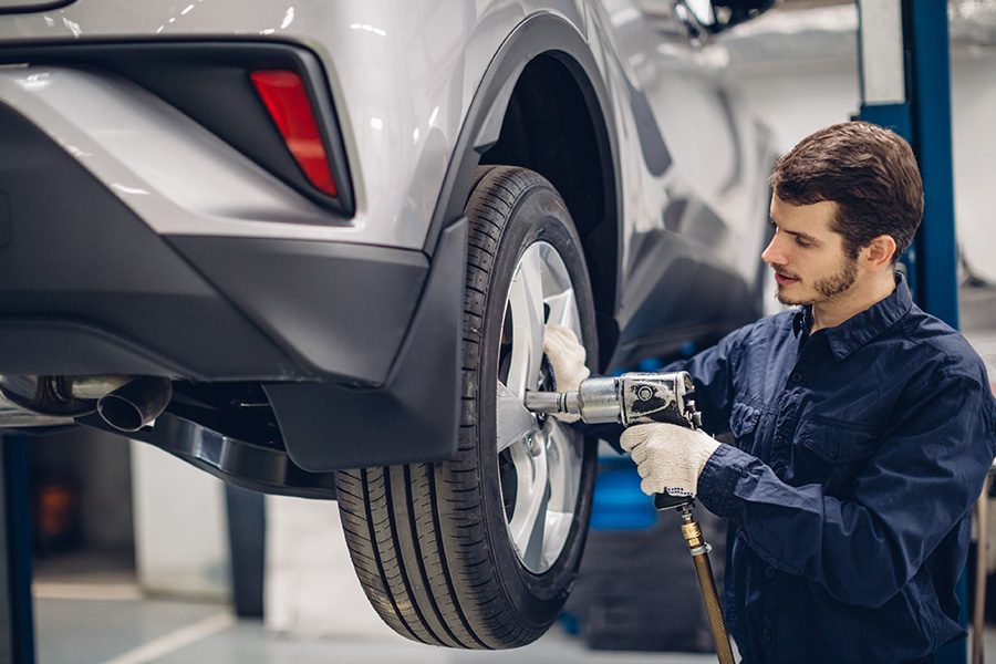 Blog - Mechanic Changing a Tire on a Silver Car at an Auto Car Repair Service Center